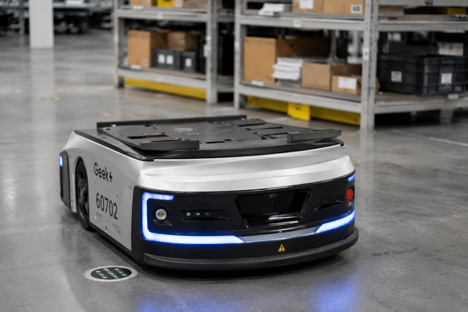 Geek+ autonomous mobile robot navigating warehouse floor with blue LED sensors